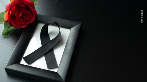 Cinta de luto y una rosa roja
