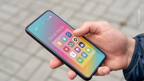 Una persona sostiene con su mano un celular.