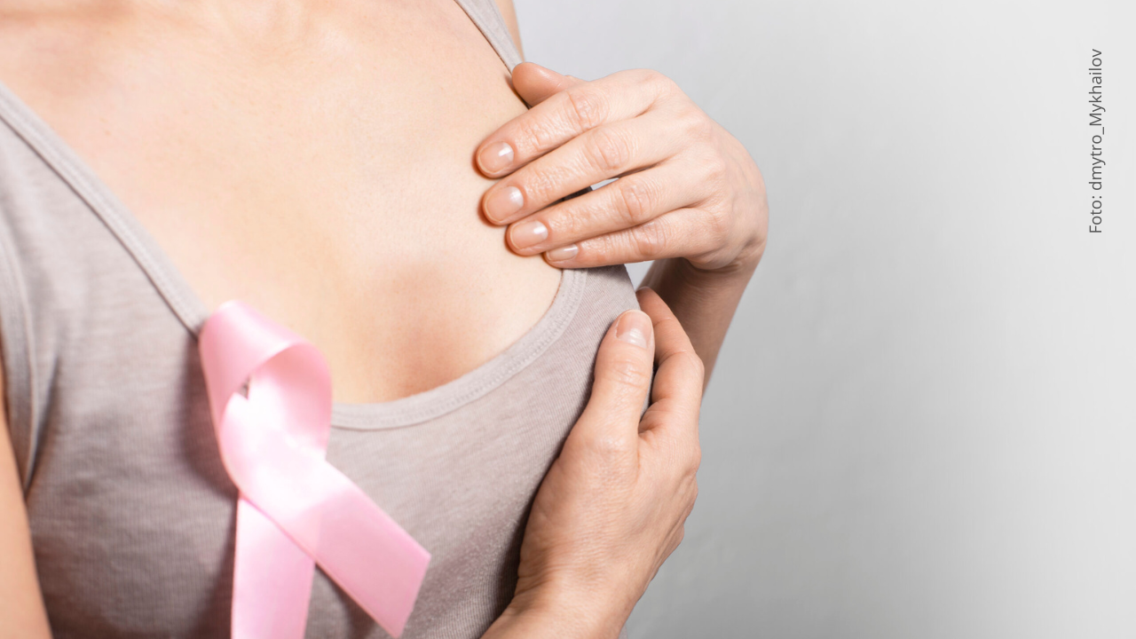 Mujer caucásica de mediana edad realizándose un autoexamen de mama.