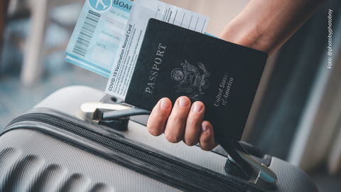 Persona con una maleta en su mano y el pasaporte.
