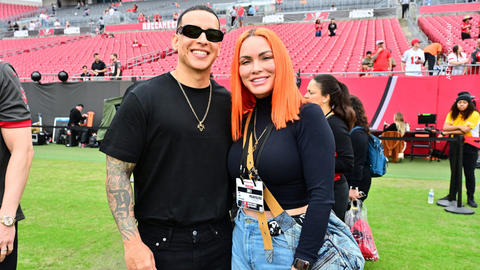 Daddy Yankee y su esposa Mireddys González posan para una foto en el campo antes del partido entre los Tampa Bay Buccaneers y los Carolina Panthers.