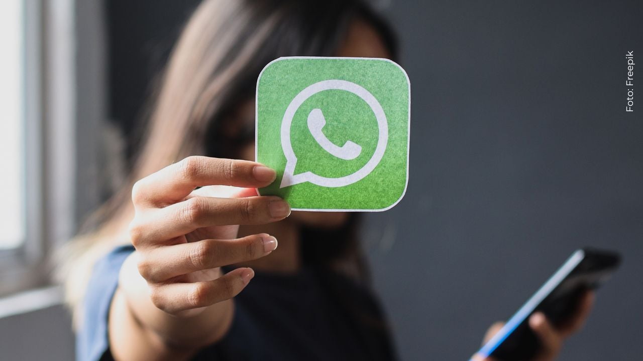Imagen de una mujer sosteniendo el logo de WhatsApp